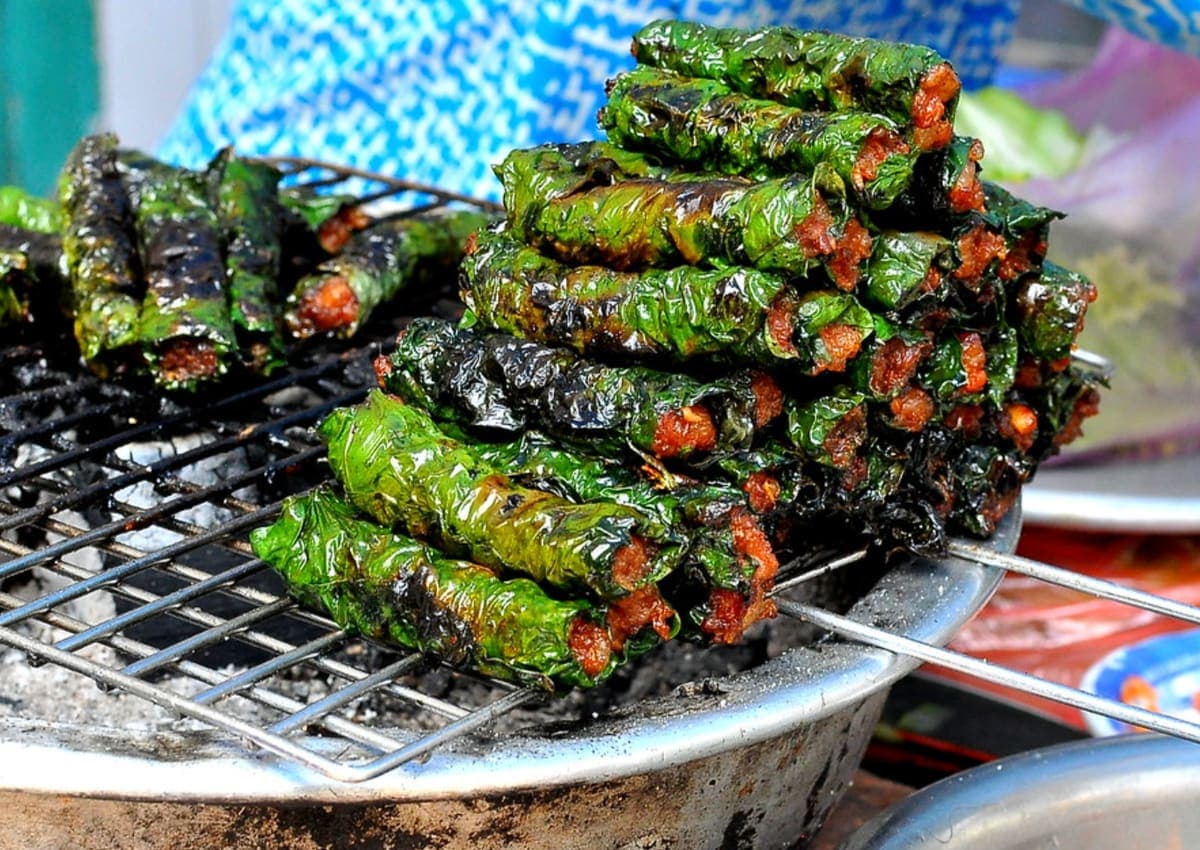Bo la lot grilling over charcoal at a Ho Chi Minh street stall