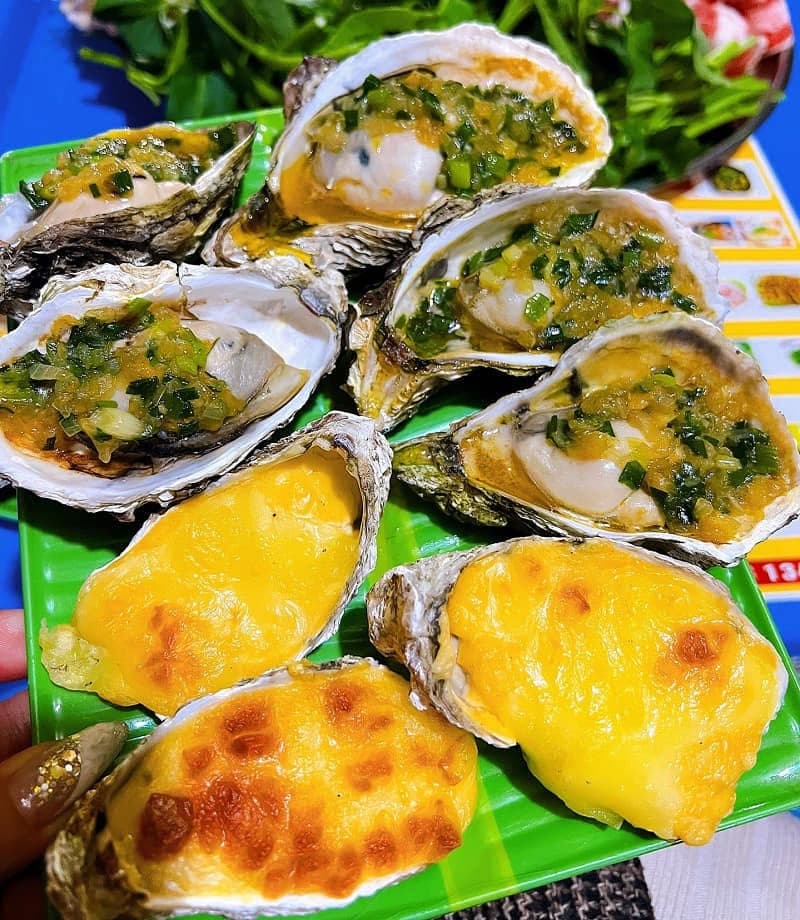 Grilled oysters topped with scallion oil and cheese at a Ho Chi Minh City street stall