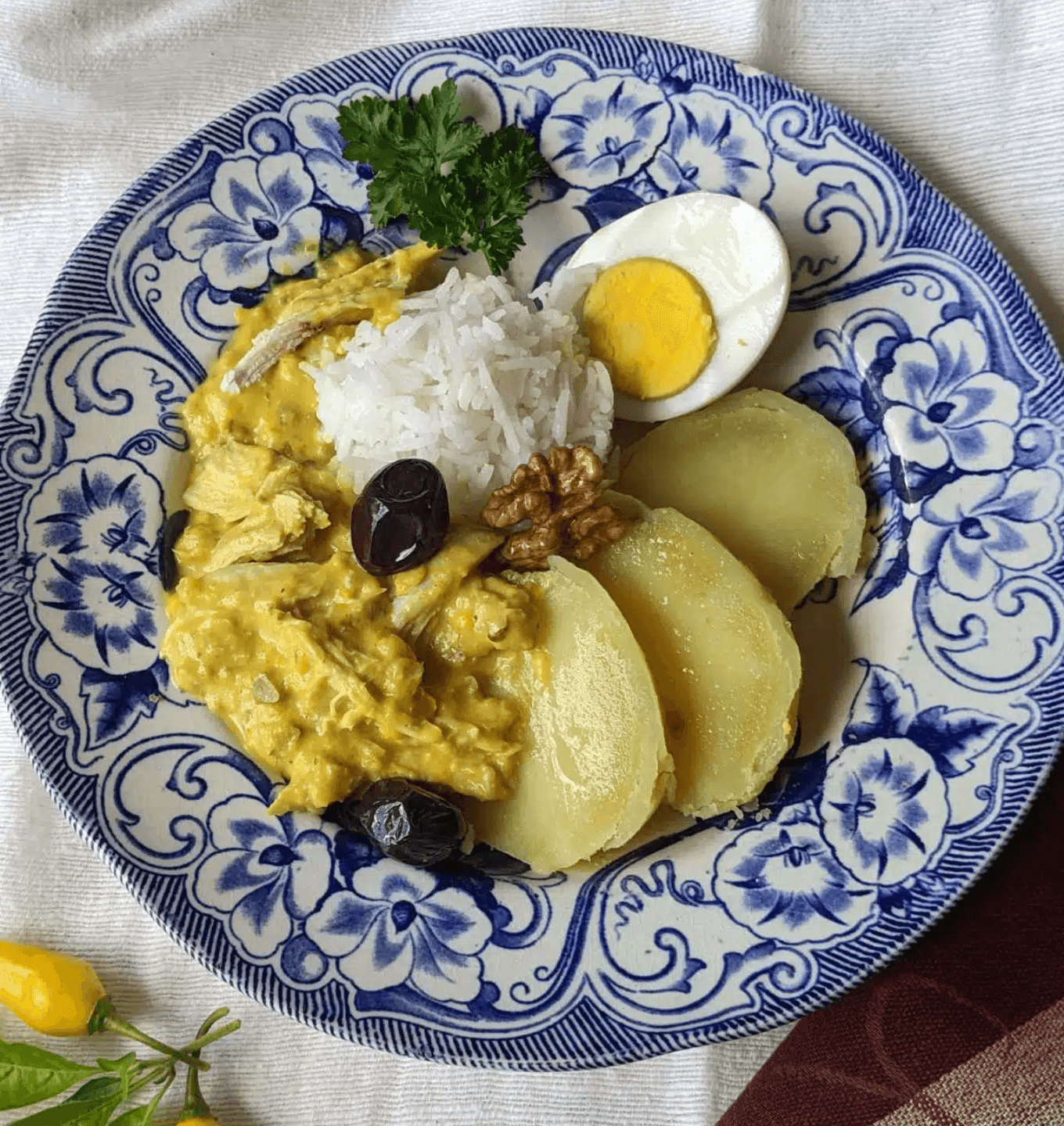 Aji de gallina served with rice and potatoes in Lima