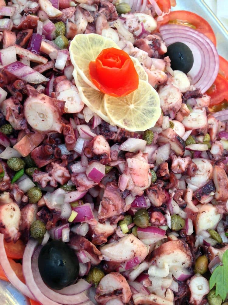 Octopus salad with red onion, capers, olives, and lemon