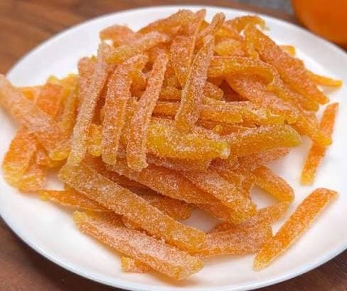 Candied orange peel strips piled on a plate