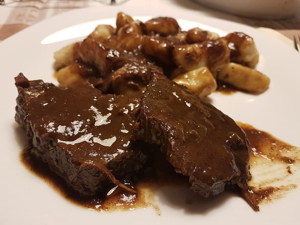 Dalmatian pasticada plated with rich dark sauce