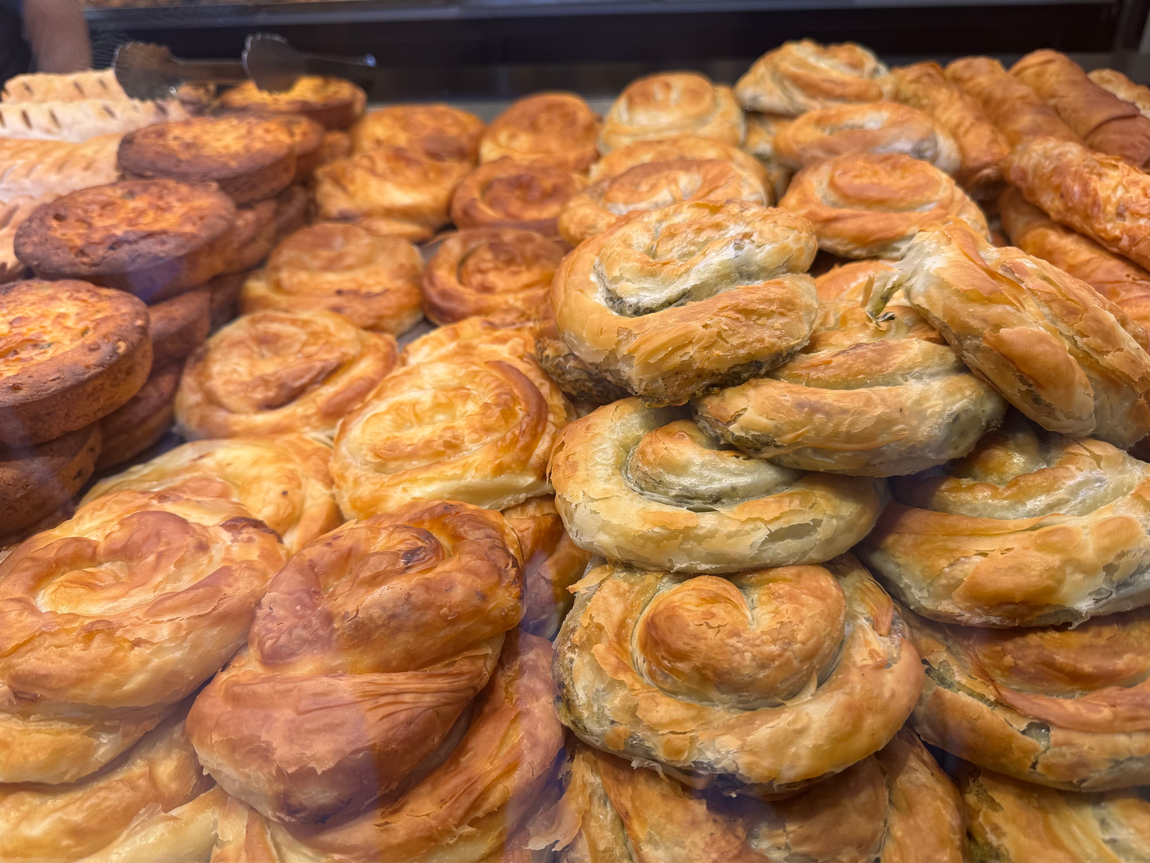 Freshly baked spinach borek pastries displayed in a bakery case