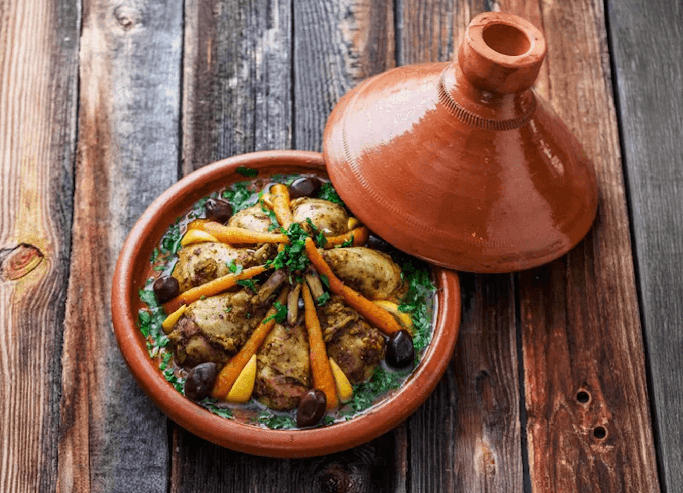 Marrakesh tagine served in a clay dish with vegetables and preserved lemon