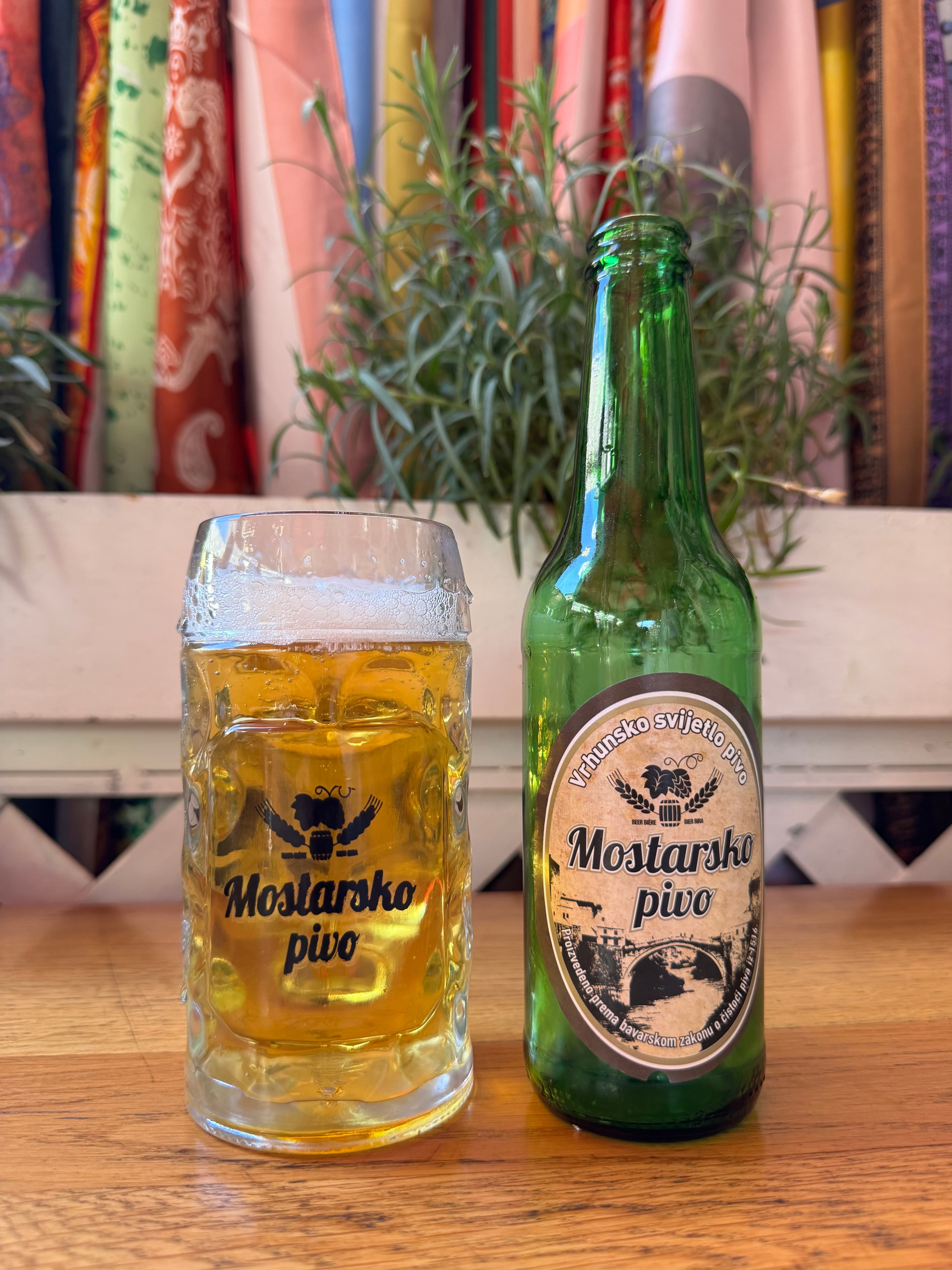 Glass and bottle of Mostarsko pivo on a table in Mostar