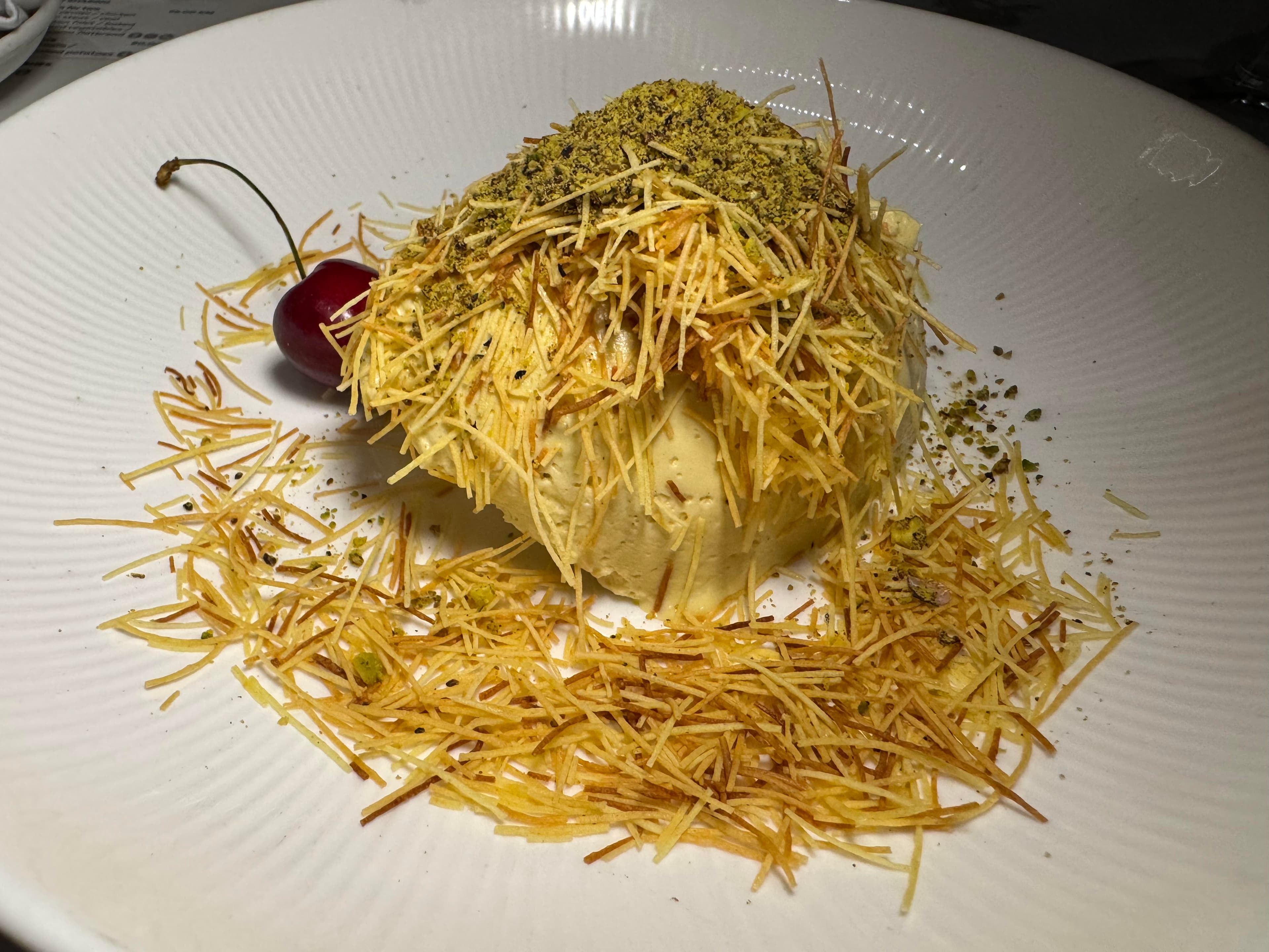 Plate of kadaif dessert topped with pistachio and crisp pastry strands in Mostar