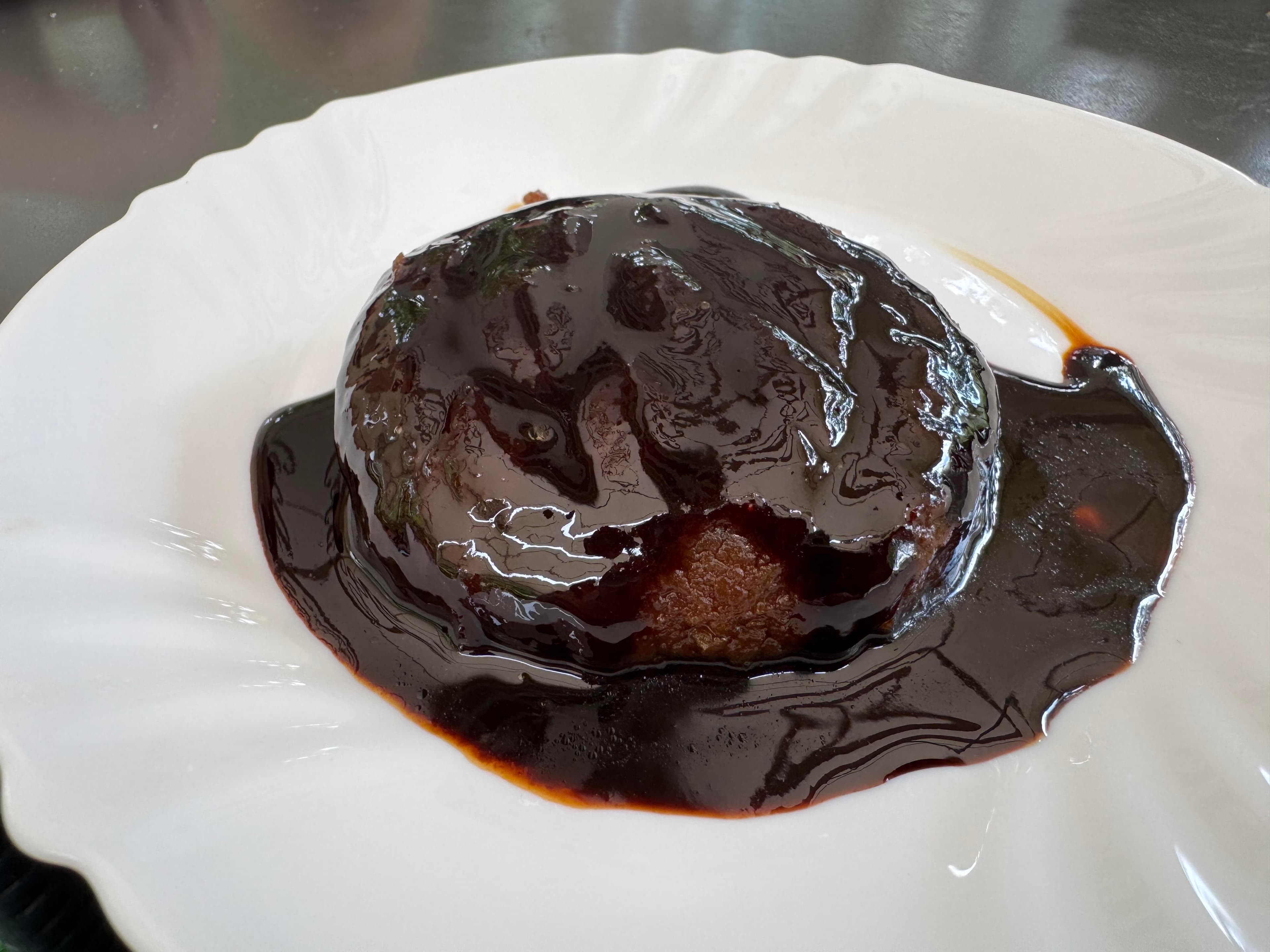 Smokvara dessert covered in dark fig glaze on a white plate in Mostar