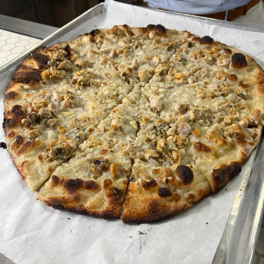 New Haven white clam pizza with clams, cheese, herbs, and a blistered crust