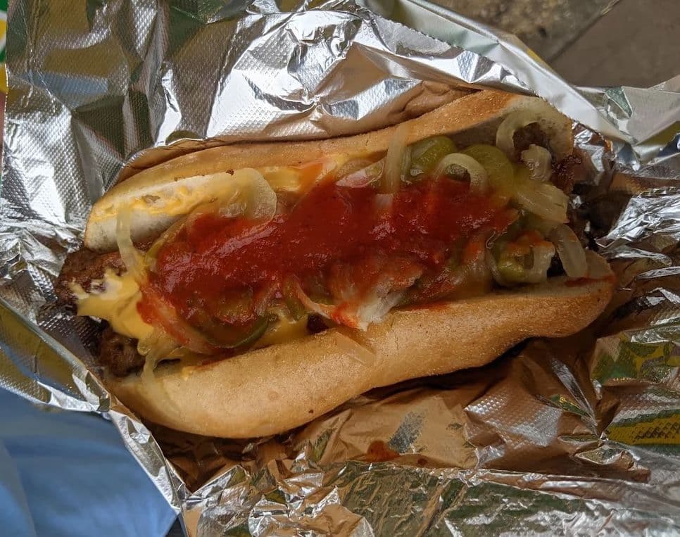 Jersey Shore sausage and peppers sandwich in foil with peppers, onions, cheese, and tomato sauce