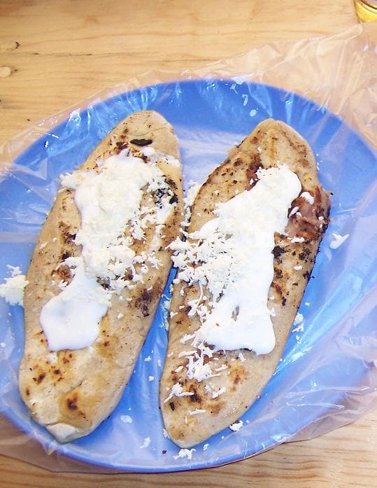 Tlacoyos topped with crema and salsa