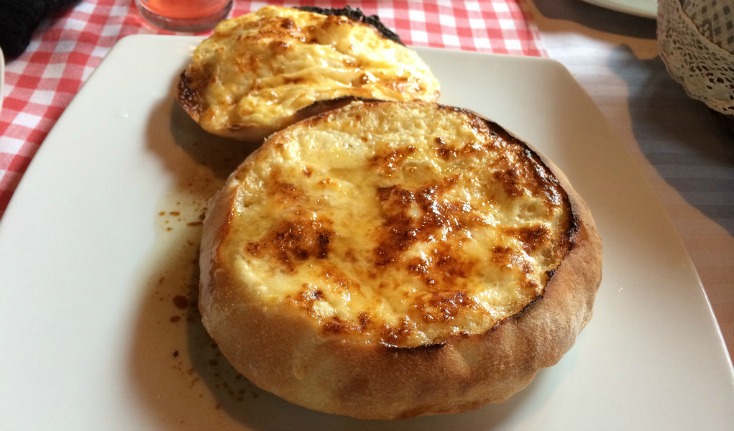 Komplet lepinja baked in round bread with a browned egg-and-kajmak topping