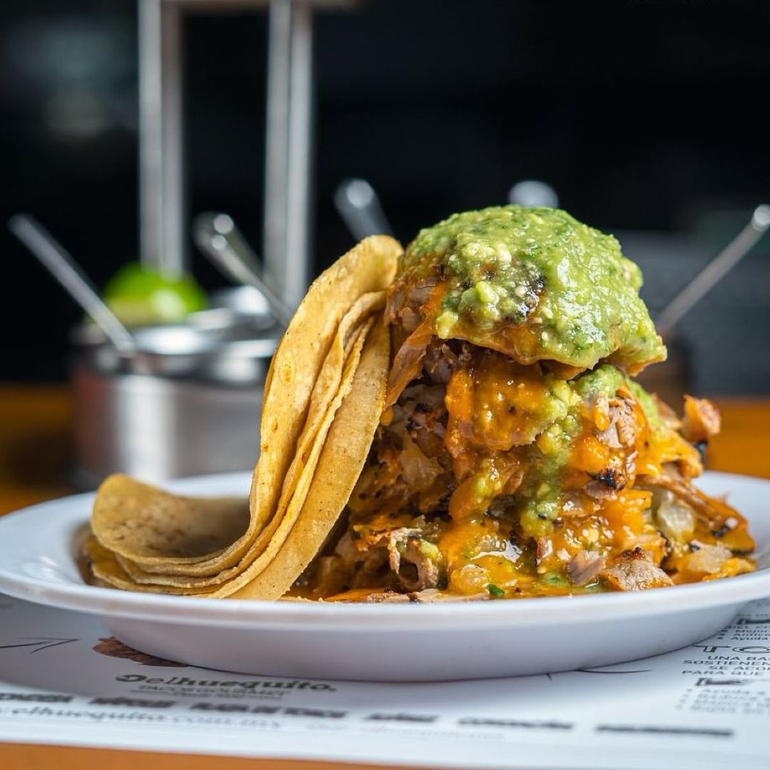 Stacked tacos al pastor with salsa and tortillas in Mexico City
