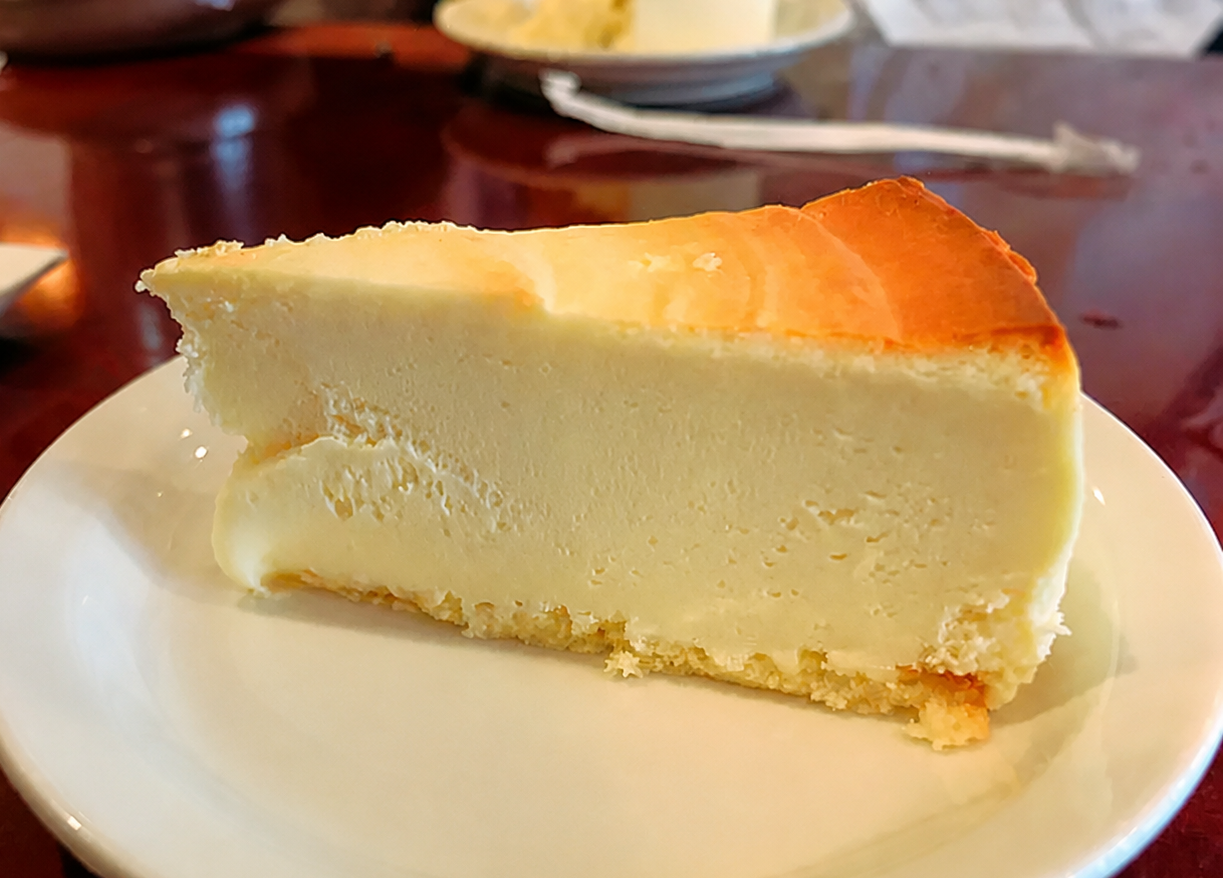 Slice of New York cheesecake on a white plate
