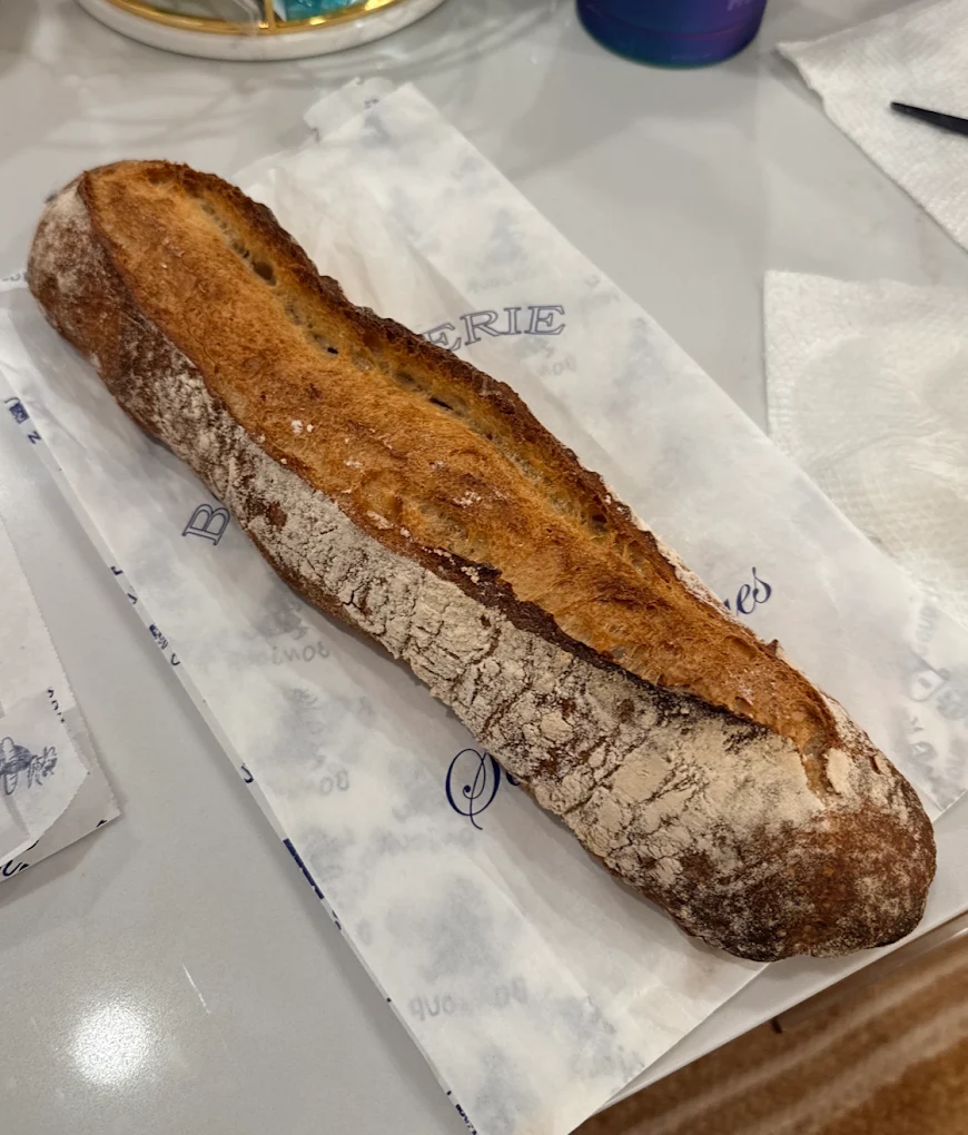 A rustic French baguette served on bakery paper