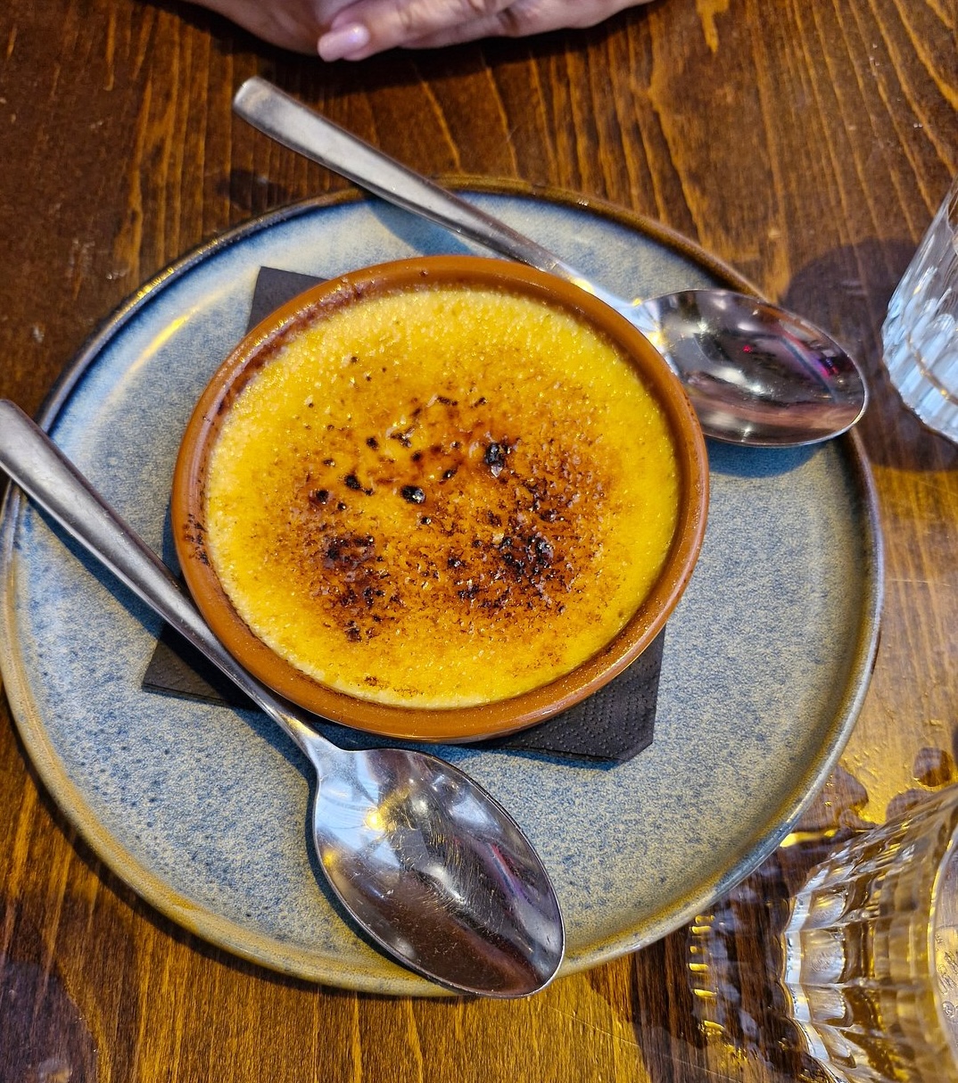 Crème brûlée with a caramelized sugar crust served on a white dish