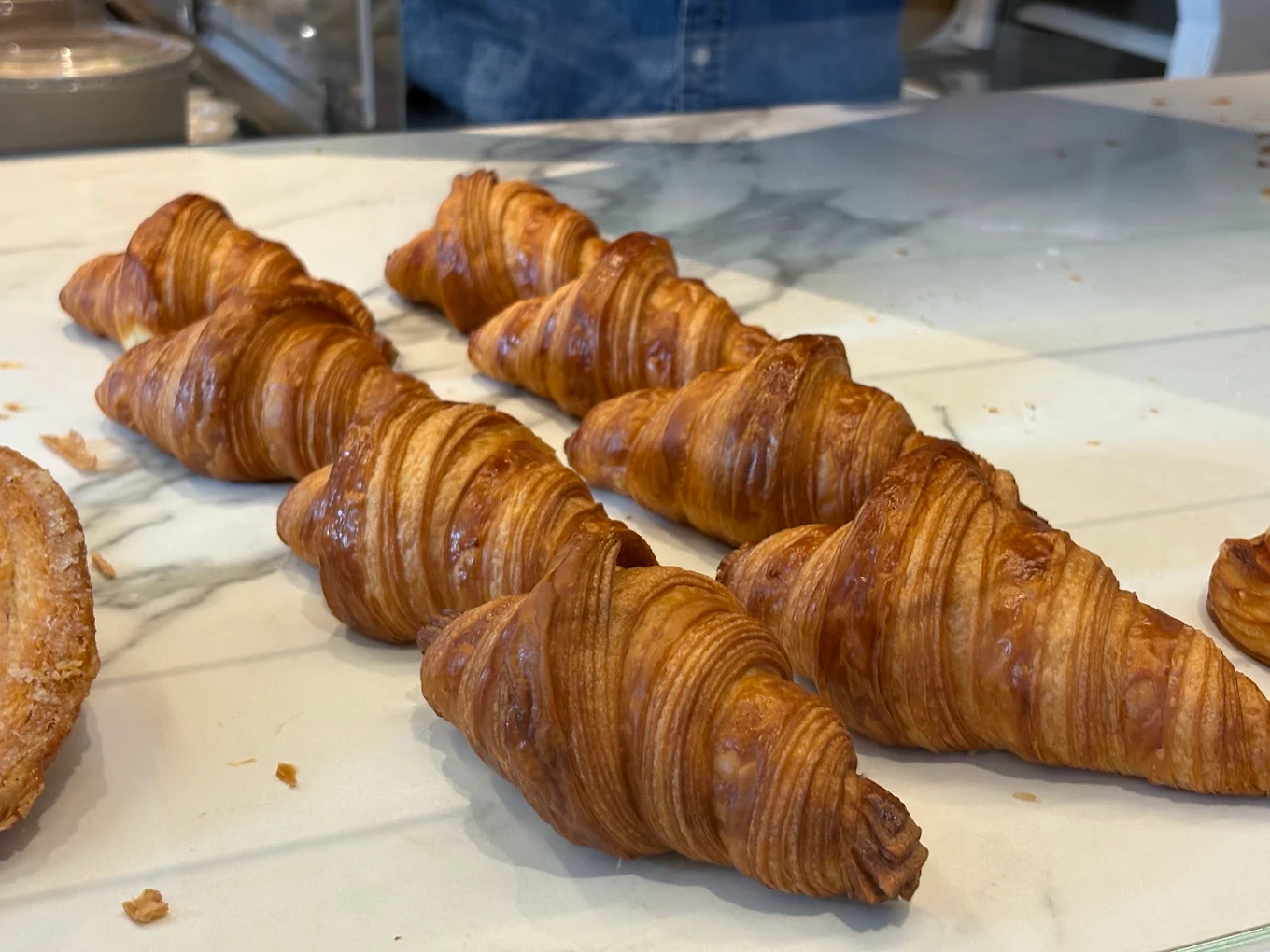 Fresh croissants and viennoiserie on a bakery tray