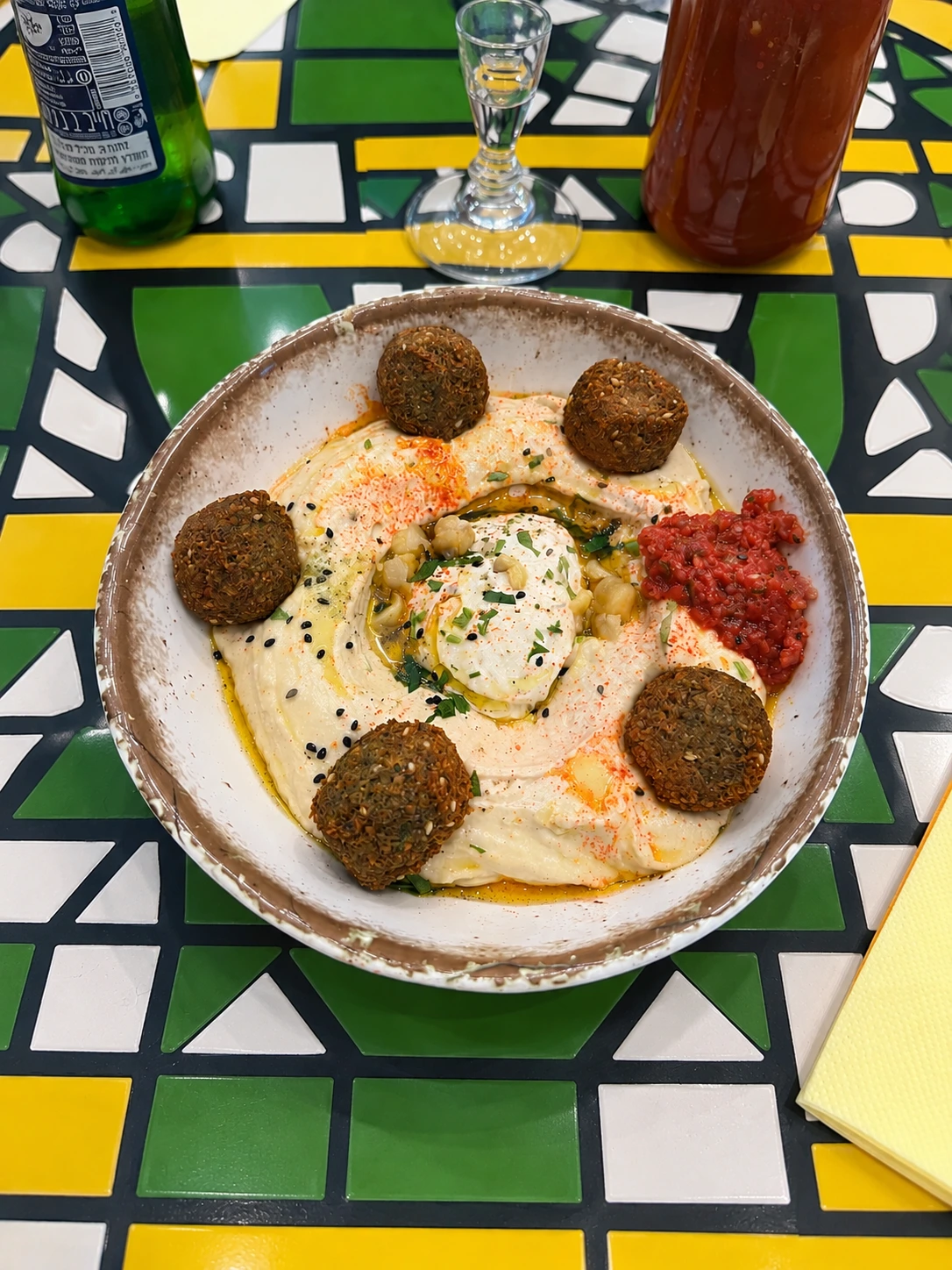 Falafel with hummus, tahini, herbs, and tomato sauce in Paris