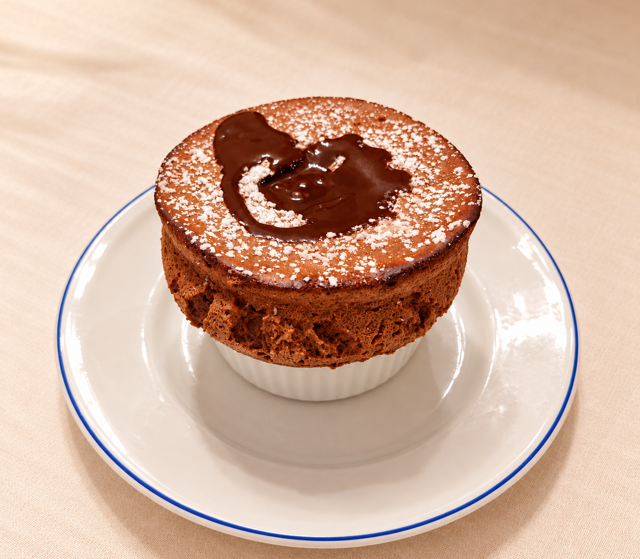 Chocolate soufflé dusted with powdered sugar and filled with warm chocolate sauce