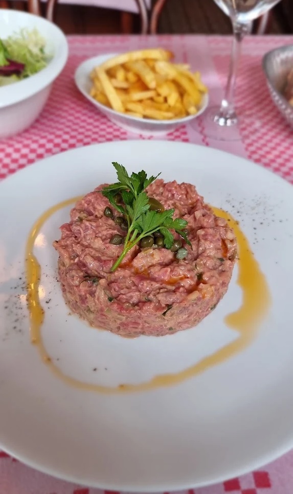 Steak tartare served with fries on a white plate