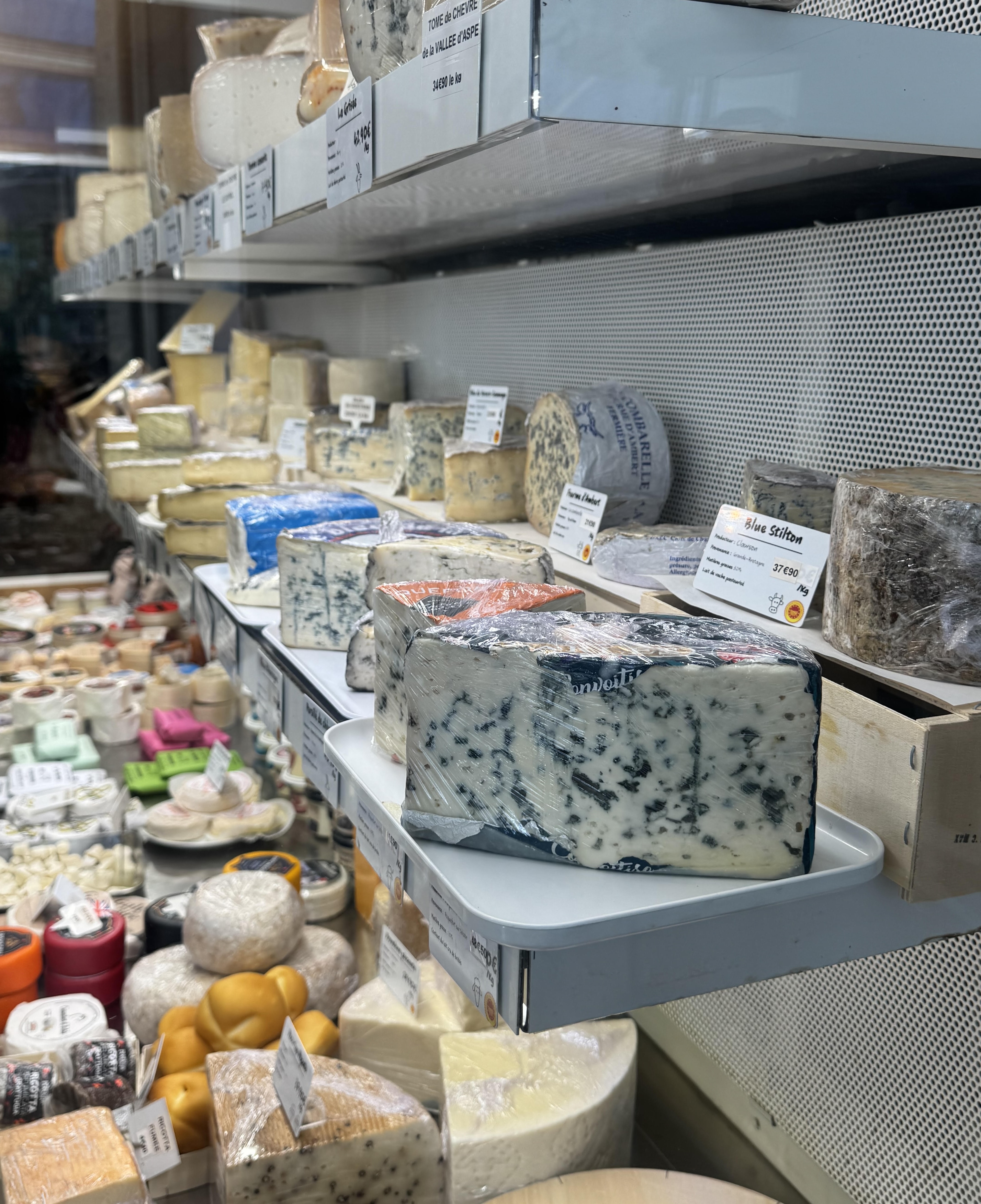 French cheeses displayed at a Paris fromagerie counter