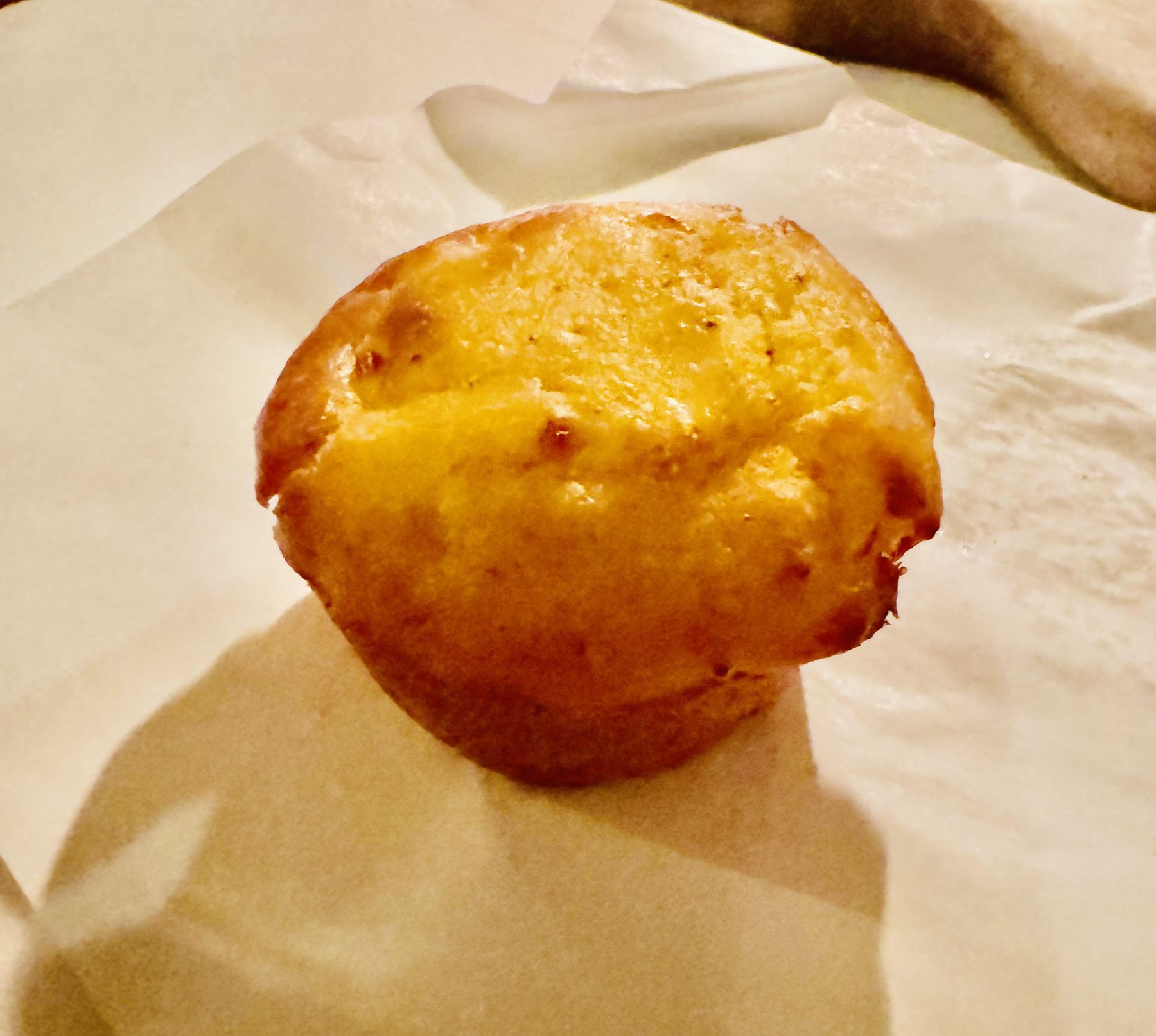 Small golden piece of proja Serbian cornbread served warm on parchment