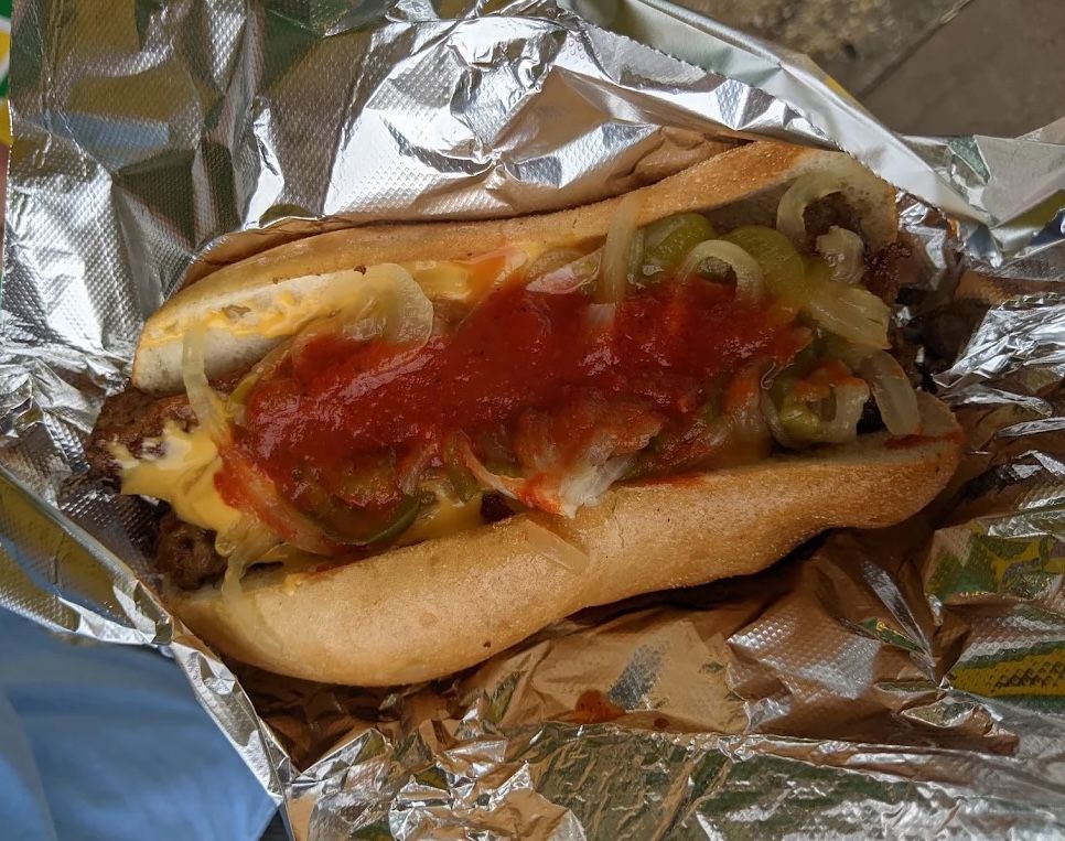 Jersey Shore sausage and peppers sandwich in foil with peppers, onions, cheese, and tomato sauce
