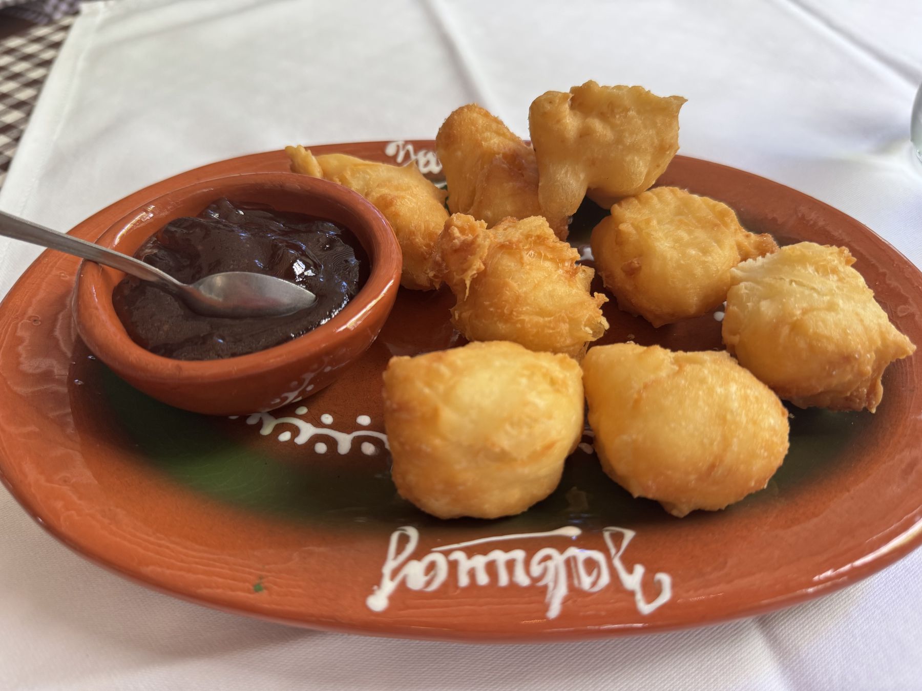 Plate of sweet Serbian uštipci served with a dark fruit jam