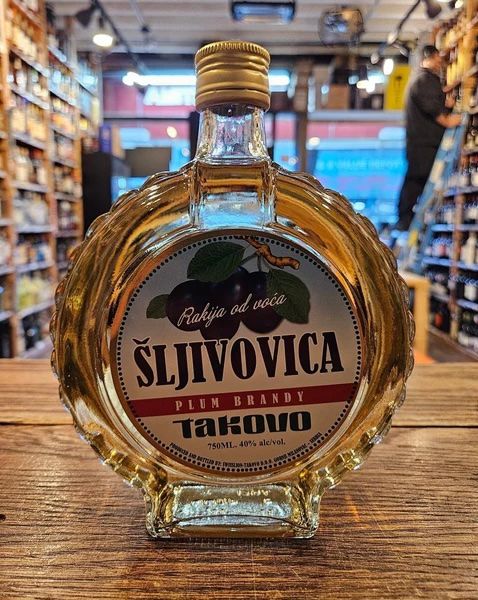 Bottle of šljivovica plum brandy displayed on a wooden counter